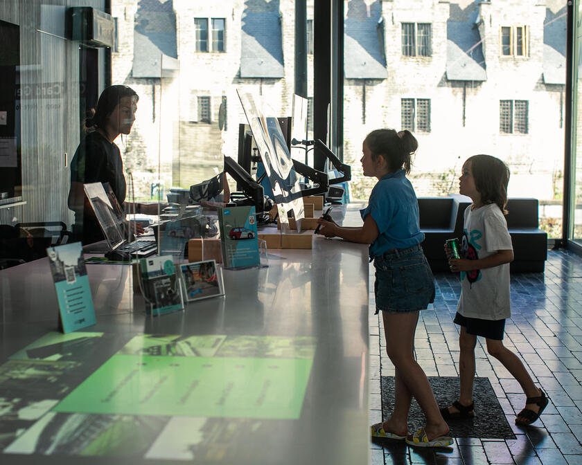 Zwei Kinder, die Informationen im Tourismusbüro von Gent anfordern