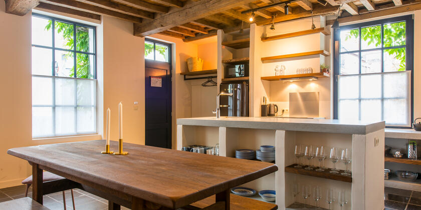 grote, open keuken met houten tafel en houten plafondgewelf 