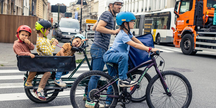 Father cycles with longtail bike with his family through the streets of Ghent
