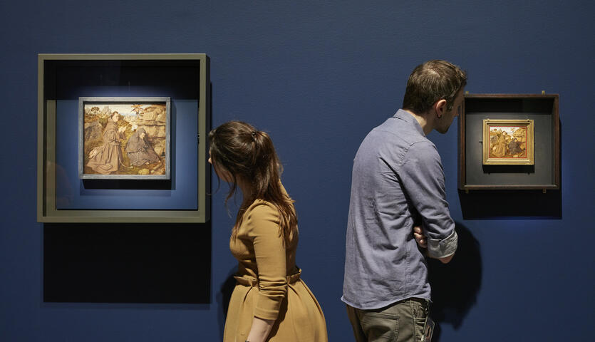een man en een vrouw die elk naar een schilderij kijken