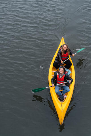 Laura und ihre Freundin sitzen zusammen in einem Kanu und fischen auf dem Oude Dokken in Gent