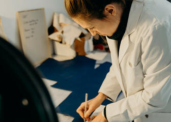 Griet draws the pattern on the leather.