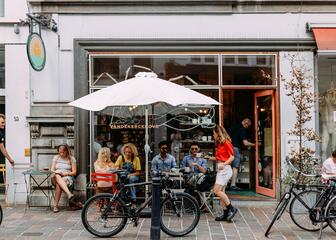 Straßenansicht des Cafés mit Menschen auf der Terrasse