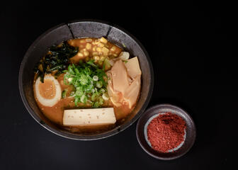 Bowl with ramen against a black background