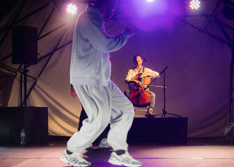 Hip-Hop-Tänzerin auf einer Bühne mit einem Musiker