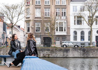 Laura und ihre Freundin unterhalten sich am Wasser in Gent entlang des Wassers