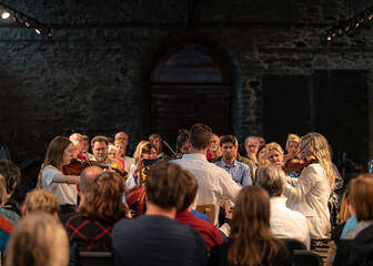 Escenas de Lauden 2023: una íntima orquesta de cuerda rodeada por el público presente en el histórico refectorio de la abadía de San Bavón