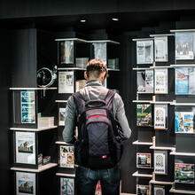 Young man with a backpack looking for information in the documentation cabinets of the tourist information office